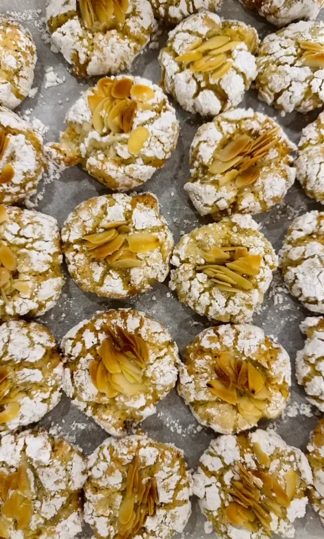 Almond topped Italian-style sweet bakes dusted with icing sugar