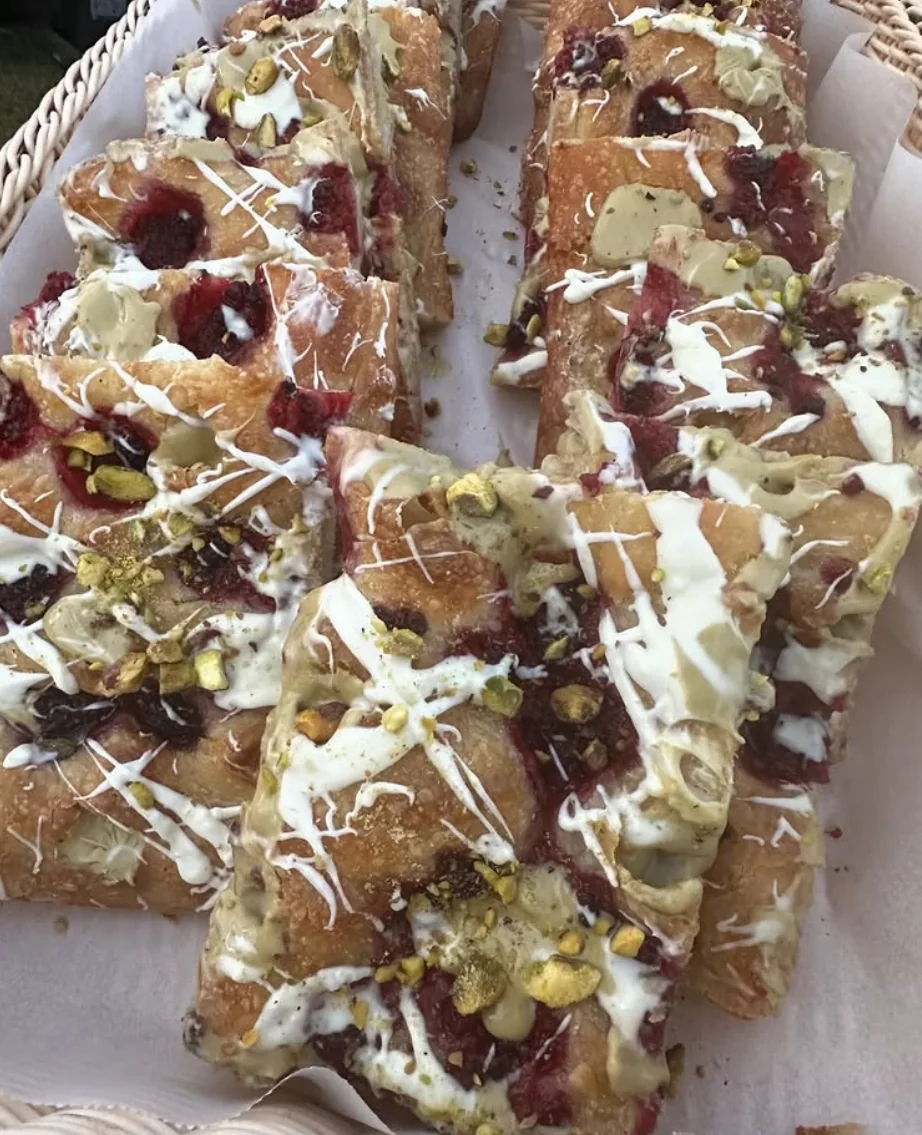 Sweet focaccia with berries, pistachio and white drizzle